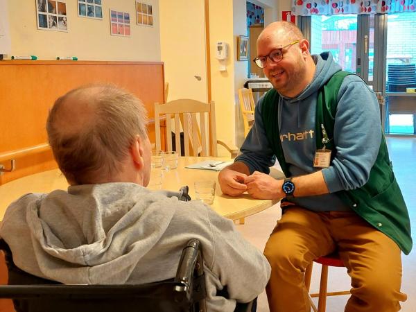 mies auttaa ikäihmistä syömisessä