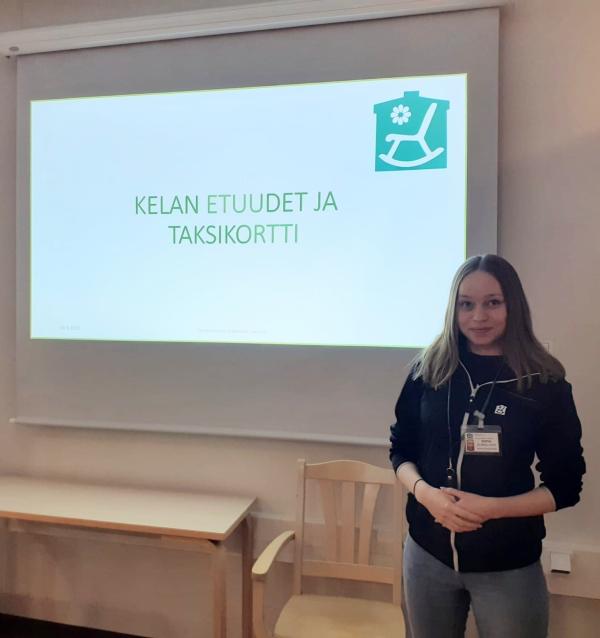 Nainen seisoo valkokankaan edessä