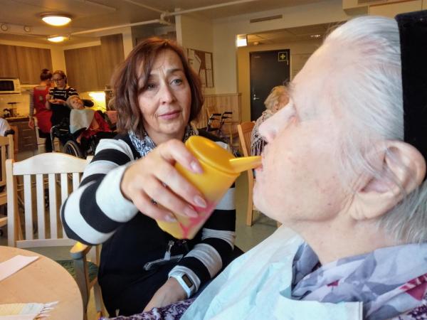 Hoitaja syöttää vanhusta