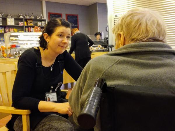 hoitaja puhuu vanhuksen kanssa