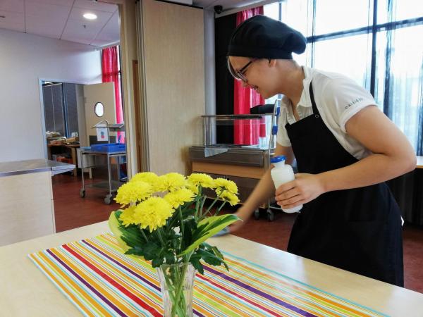 tyttö pyyhkii pöytää