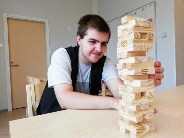 Mies pelaa huojuvaa tornia