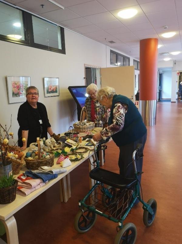 Nainen katsoo pöydällä esillä olevia koristeita