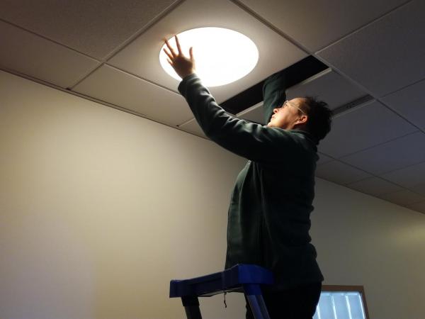 talonmies kiinnittää kattolamppua