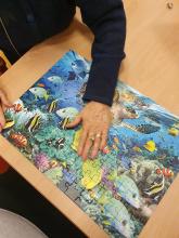 Kädet kasaavat palapeliä