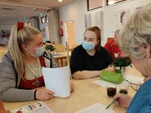 Kaksi hoitajaa katsoo toisiaan ja nauraa