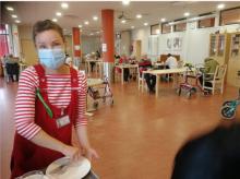 hoitaja korjaa astioita