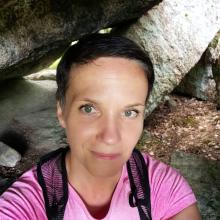 nainen seisoo metsässä