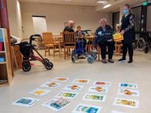 Mies heittää hernepussia ja yrittää osua lattialla olevaan maaliin.